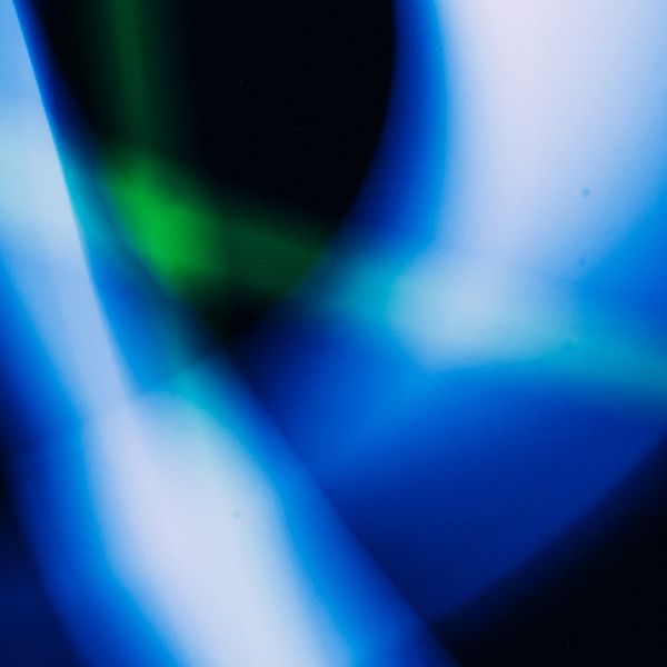 Abstract image representing flow and energy with light streaks on a dark background.